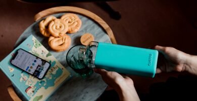 person holding teal and green plastic bottle